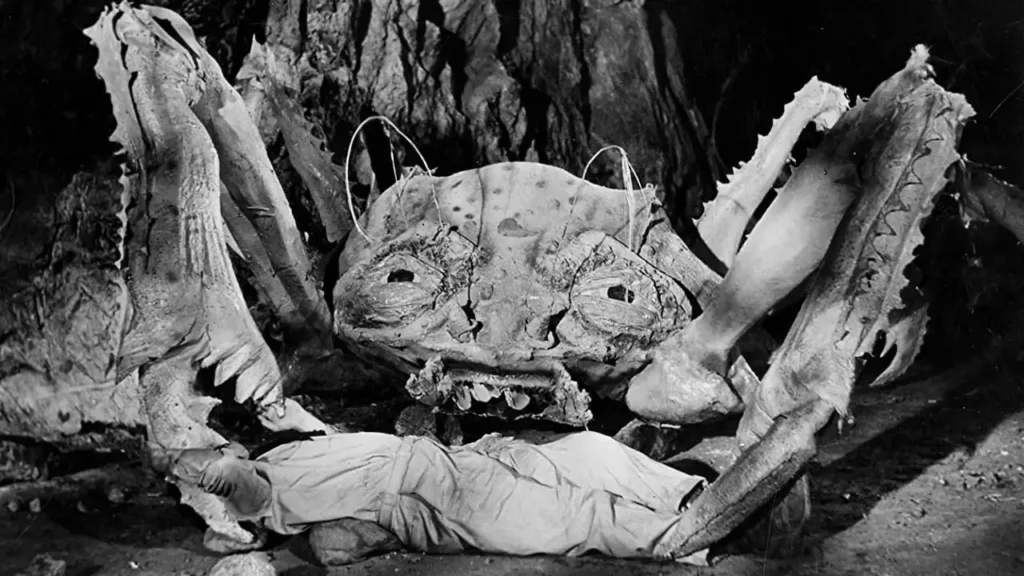 Σκηνή από την ταινία 'Attack of the Crab Monsters' (1957): Ένα γιγαντιαίο καβούρι επιτίθεται σε θύμα μέσα σε σκοτεινή σπηλιά.