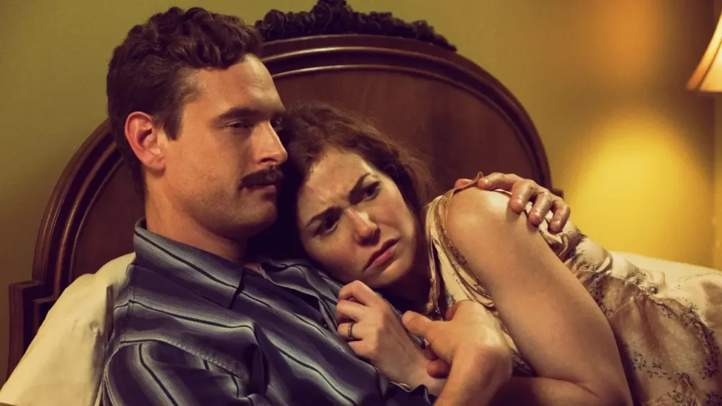 Δύο άνθρωποι αγκαλιάζονται σε σκοτεινή ατμόσφαιρα, με μυστηριώδη και ανήσυχη διάθεση, από σκηνή της σειράς