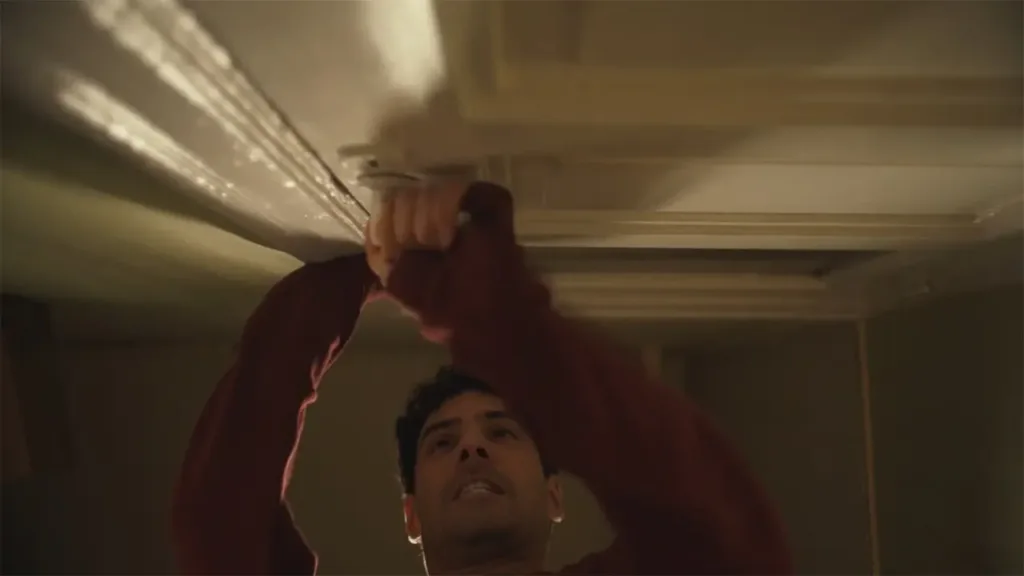 Σκηνή από το «Gumboro» (2025) όπου χαρακτήρας προσπαθεί να ανοίξει παγιδευμένη πόρτα.