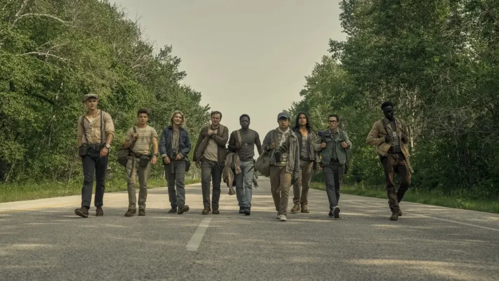 Μια ομάδα τρομακτικών περιπατητών βαδίζει στην ερημική άσφαλτο, σκηνή από την ταινία “The Long Walk” (2025)﻿.