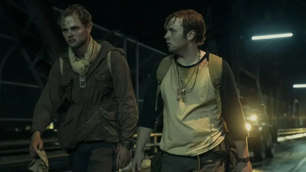 Δύο άντρες περπατούν σε μια σκοτεινή γέφυρα, σε σκηνή από την ταινία «The Long Walk» (2025).