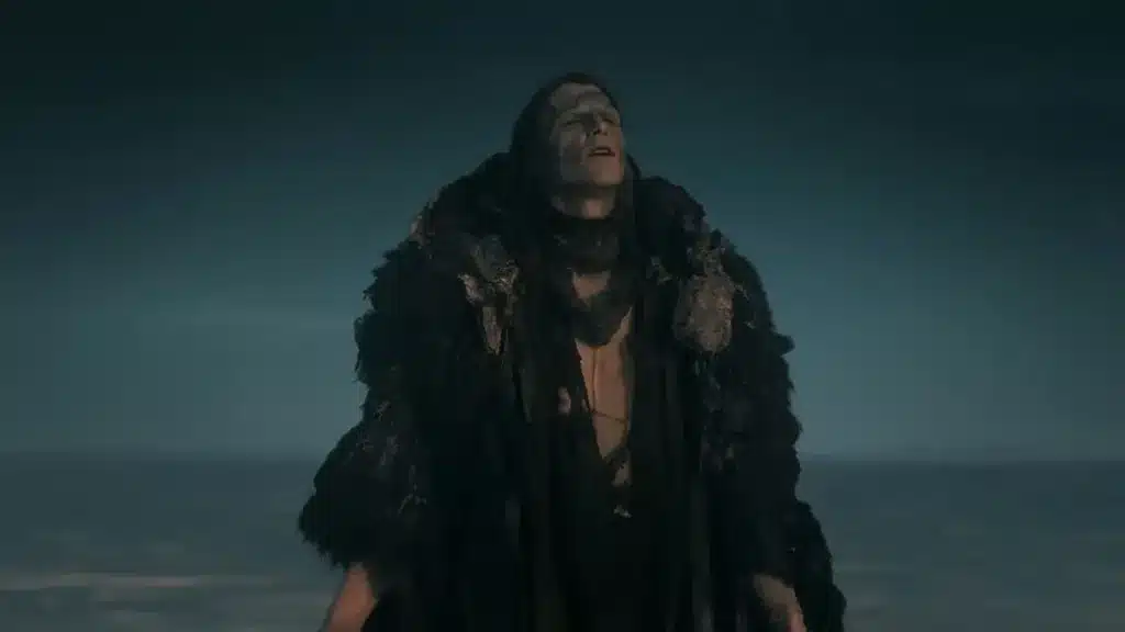 Το πλάσμα του Φρανκενστάιν στέκεται μόνο του σε παγωμένο, σκοτεινό τοπίο, τυλιγμένο με κουρέλια και γούνες, σε σκηνή από την ταινία «Frankenstein» (2025).